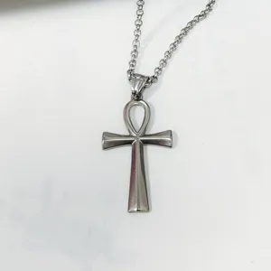 Close-up of polished stainless steel Ankh cross pendant on a silver necklace chain.
