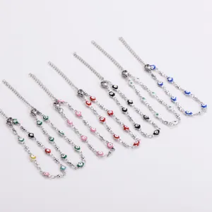 Vari colori di braccialetti con perline malocchio in acciaio inossidabile su sfondo bianco