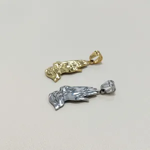 Detalle de colgantes de manos rezando en oro y plata de acero inoxidable pulido