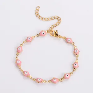 Dettaglio di un bracciale in acciaio inossidabile placcato oro con occhi rosa