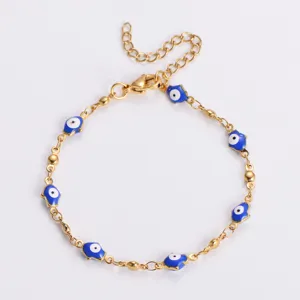 Dettaglio di un bracciale in acciaio inossidabile dorato con ciondoli hamsa occhio blu