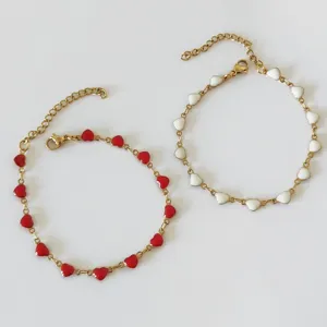 Detailed macro shot of gold stainless steel heart enamel bracelets in red and white colors