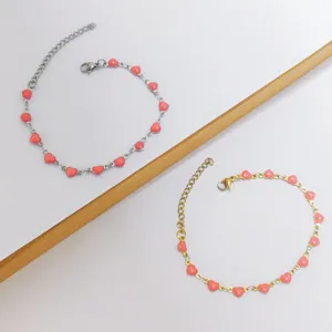 Close-up of minimalist stainless steel bracelets featuring delicate pink enamel heart charms