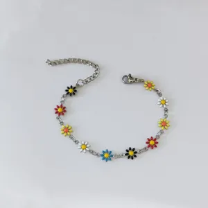 Dettaglio dei ciondoli a margherita in smalto colorato su bracciale a catena in acciaio