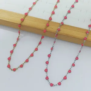 Close-up of stainless steel heart-link necklaces with red enamel dripping oil detail