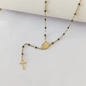Detail of stainless steel rosary necklace with black beads and gold cross pendant