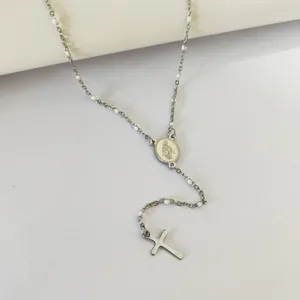 Detailed macro view of a silver stainless steel rosary necklace with cross and white beads.