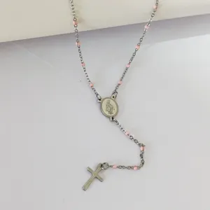Close-up of silver stainless steel rosary necklace with pink enamel beads and cross.