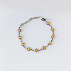 Vista dettagliata di un bracciale in acciaio inox con ciondoli a margherita rosa.