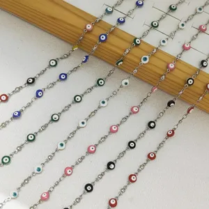 Primer plano de los dijes del ojo turco de esmalte de colores en cadenas de acero inoxidable
