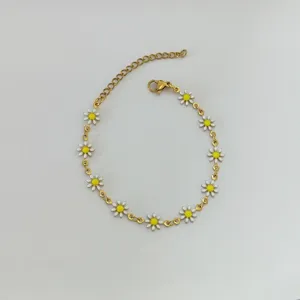 Vista dettagliata di un bracciale dorato in acciaio inossidabile con margherite smaltate
