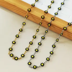 Detail shot of stainless steel daisy necklaces with yellow flowers in gold and silver