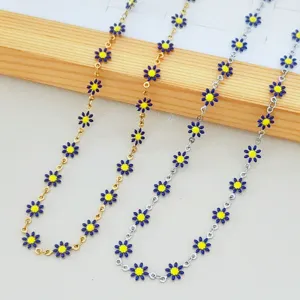 Close-up of stainless steel daisy chain necklaces with blue and yellow enamel flowers