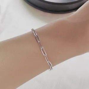 Detailed view of a silver stainless steel paperclip chain bracelet worn on a wrist