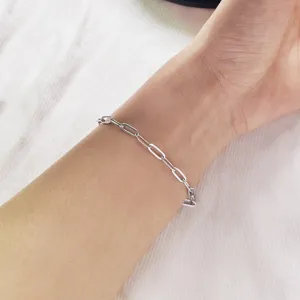 Close-up view of a minimalist silver stainless steel paperclip chain bracelet worn on the wrist