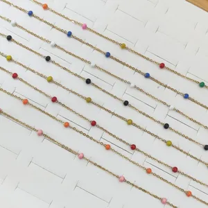 Macro view of colorful dopamine enamel beads on a dainty gold stainless steel chain