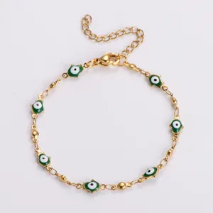 Vista dettagliata di un bracciale in acciaio dorato con ciondoli mano di Fatima verde