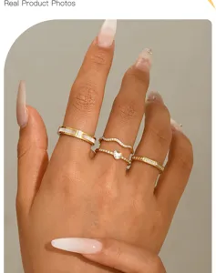 Primer plano de anillos minimalistas dorados con brillantes diseños de corazones y ondas