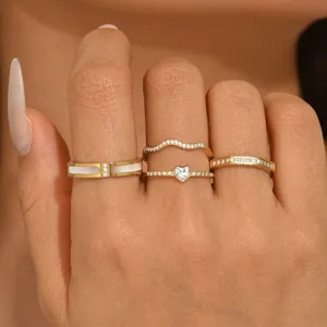 Elegante juego de cuatro anillos de oro minimalistas con diseños de corazón y ondas