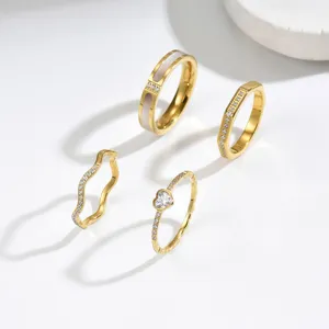 Conjunto de anillos dorados minimalistas con diseños de corazón y ondas y circonitas
