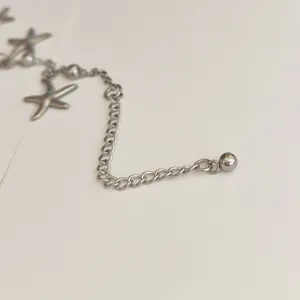 Detail macro view of stainless steel starfish anklet extension chain for beach jewelry