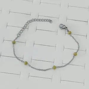 Detail shot of stainless steel bracelet with lime green enamel beads and lobster clasp