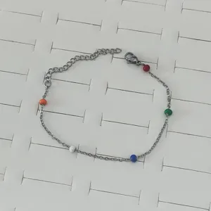 Close-up of colorful drip oil beads on a silver-tone stainless steel chain bracelet