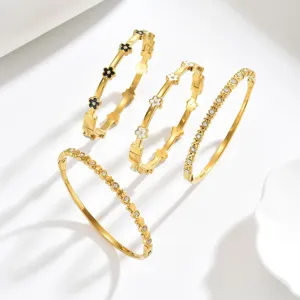 Prachtige vergulde armbandset met zwart-witte emaille bloemen en glanzende strass-steentjes