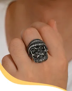 Close-up of a vintage bearded skull ring with a beanie on a person's hand