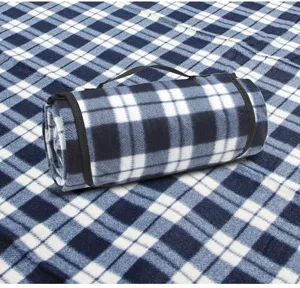 Detailweergave van opgerolde blauwe geruite picknickdeken met handvat.