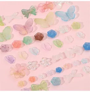 Vista detallada de cuentas de acrílico esmerilado con forma de mariposa y flor con degradados