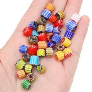 Colorful 8mm Millefiori glass beads for DIY jewelry held in hand for scale.