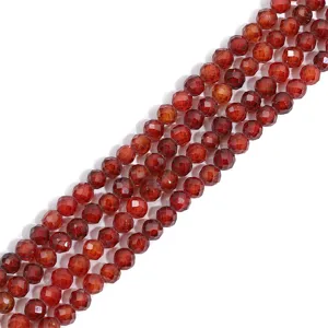 Close-up of faceted dark red synthetic zircon beads showing intricate geometric cut