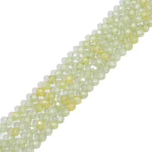 Detailed view of faceted synthetic zircon beads in light green and yellow hues for jewelry.