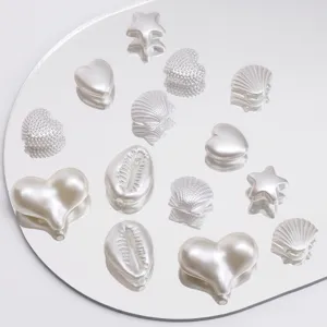 Detailweergave van witte ABS-parels in hart-, ster- en schelpvormen voor handwerk