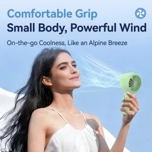 Model using portable mint green handheld fan outdoors with visible wind effects