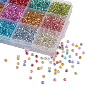 Cuentas de vidrio de colores con centro plateado en una caja organizadora para joyería manual.