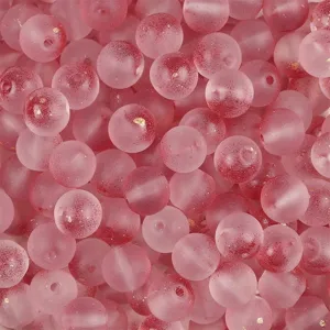 Close-up of frosted pink glass beads with red gradients and shimmering gold powder.