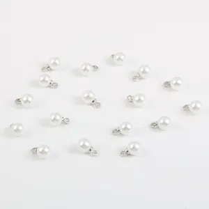 Gros plan de pendentifs en perles d'imitation ABS blanches rondes avec boucles argentées.