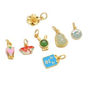 Detail view of various gold-plated enamel charms featuring lucky motifs for DIY jewelry