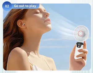Close-up of a white handheld portable USB fan being used by a woman outdoors in the sun