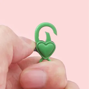 Gros plan d'un fermoir mousqueton vert en forme de cœur pour la création de bijoux DIY