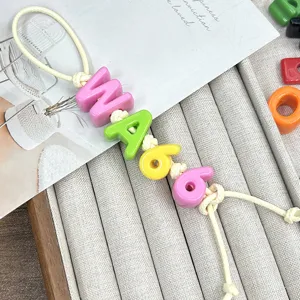 Close-up of colorful acrylic alphabet and number beads on a string for DIY crafts