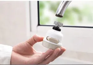 Detailed view of white kitchen faucet aerator being installed on a metal tap nozzle