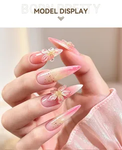 Vue détaillée du nail art dégradé rose avec des fleurs 3D et de fines paillettes