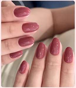 Gros plan d'un vernis à ongles gel une étape rose brillant sur des ongles.
