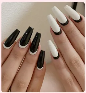 Gros plan d'ongles cercueils à pointe française noirs et blancs brillants