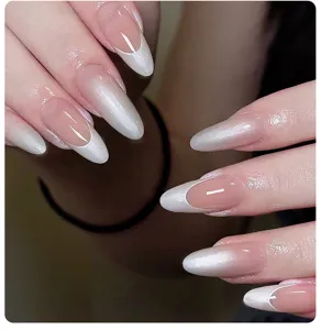 Detailed view of elegant pearlescent white gradient French tip almond shaped press-on nails
