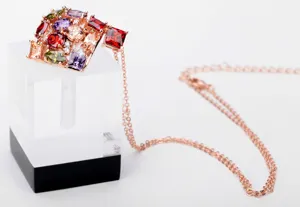 Gedetailleerde close-up van veelkleurige zirkoonstenen op een prachtige roségouden hanger