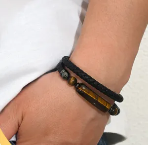 Close-up detail of a men's double-strand braided leather and tiger eye bead bracelet.
